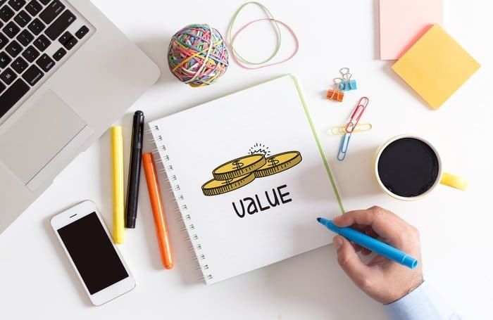 Pens and a notebook on a desk with the word value