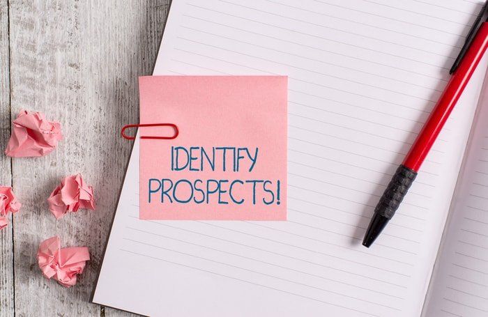 A note and pad on a desk with the word identity prospects