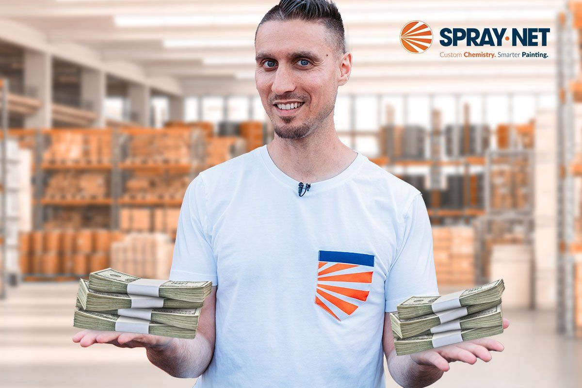Spray-Net owner standing in a hardware store aisle holding stacks of cash in each hand
