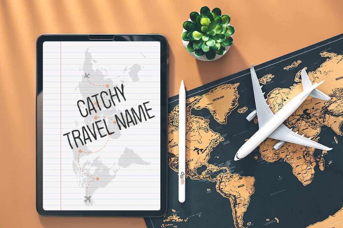 Top-down shot of a travel agent’s desk with a succulent, a miniature airplane, a black and orange map of the world, and a tablet with the words "catchy travel name" on it